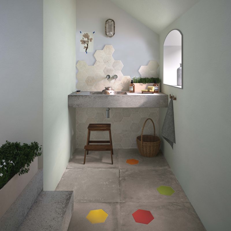 Salle de bain avec inserts hexagonaux colorés dans carreaux gris