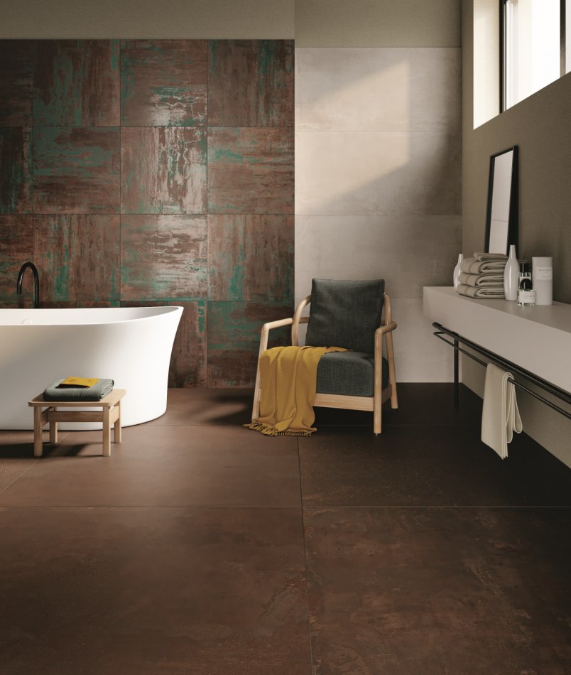 Un touche métallique dans une salle de bain avec carrelage au sol et au mur.