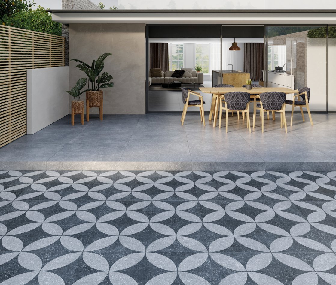 Terrasse prolongée en carrelage gris aspect carreaux ciment anciens.