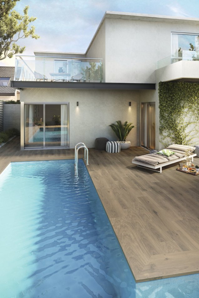 Carrelage imitation bois naturel au pourtour de cette piscine en L