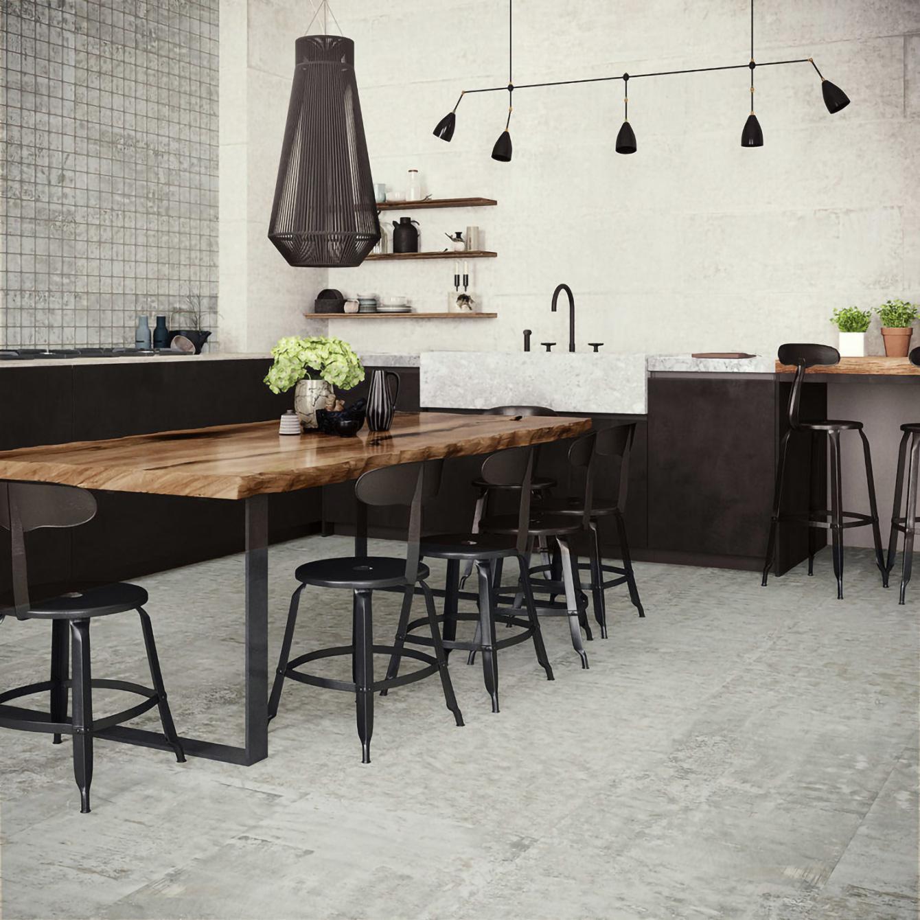 Cuisine avec grande table en bois et mur effet béton