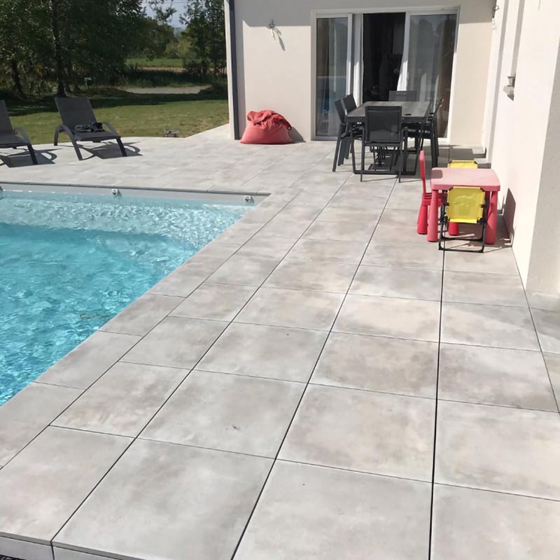 Un carrelage effet béton pour une terrasse avec piscine familiale par Giani Carrelage à Tarbes (65)