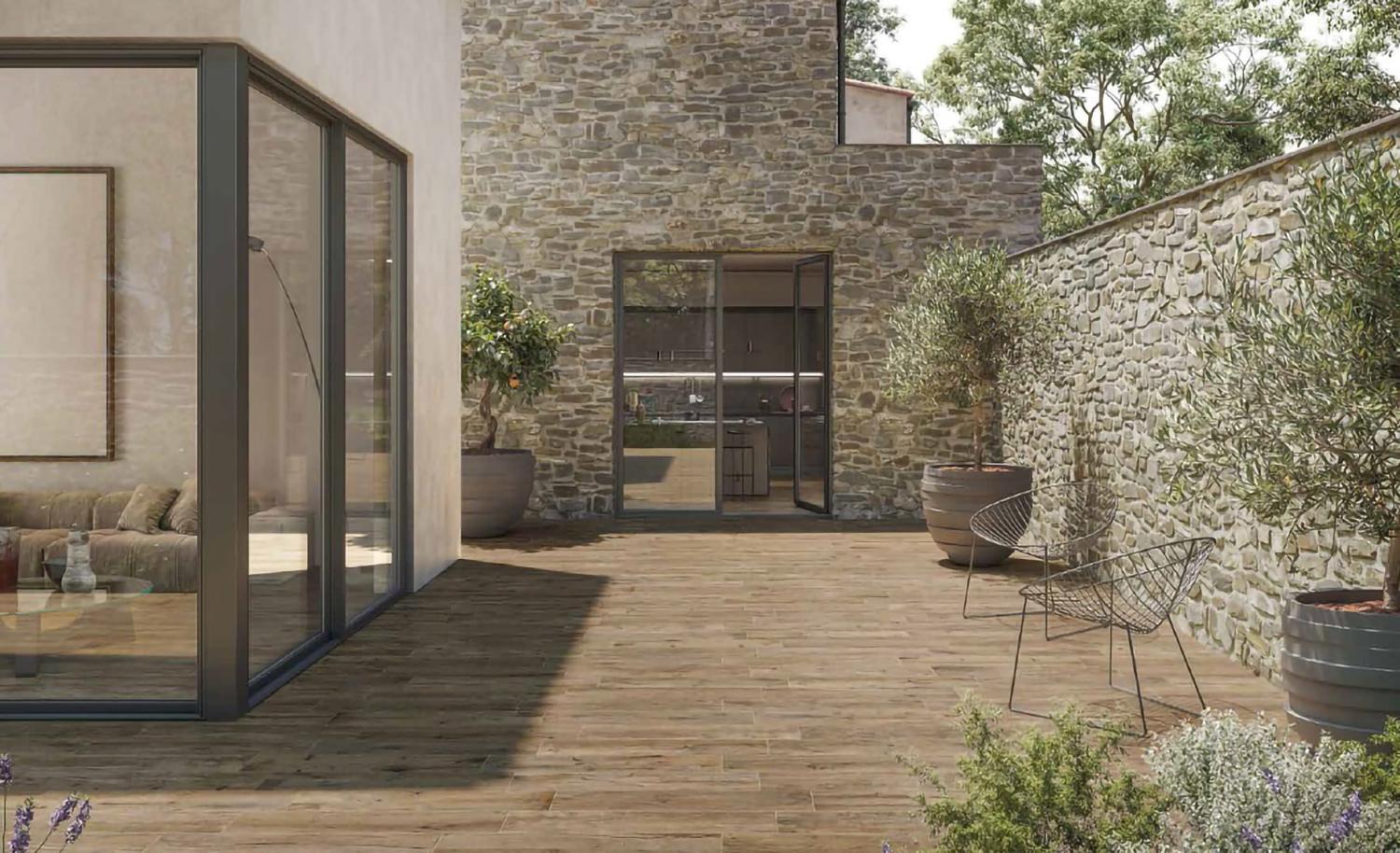 Terrasse ou patio, le carrelage imitation bois est le trait d'union entre l'authenticité des murs de pierre et la modernité de l'agrandissement.