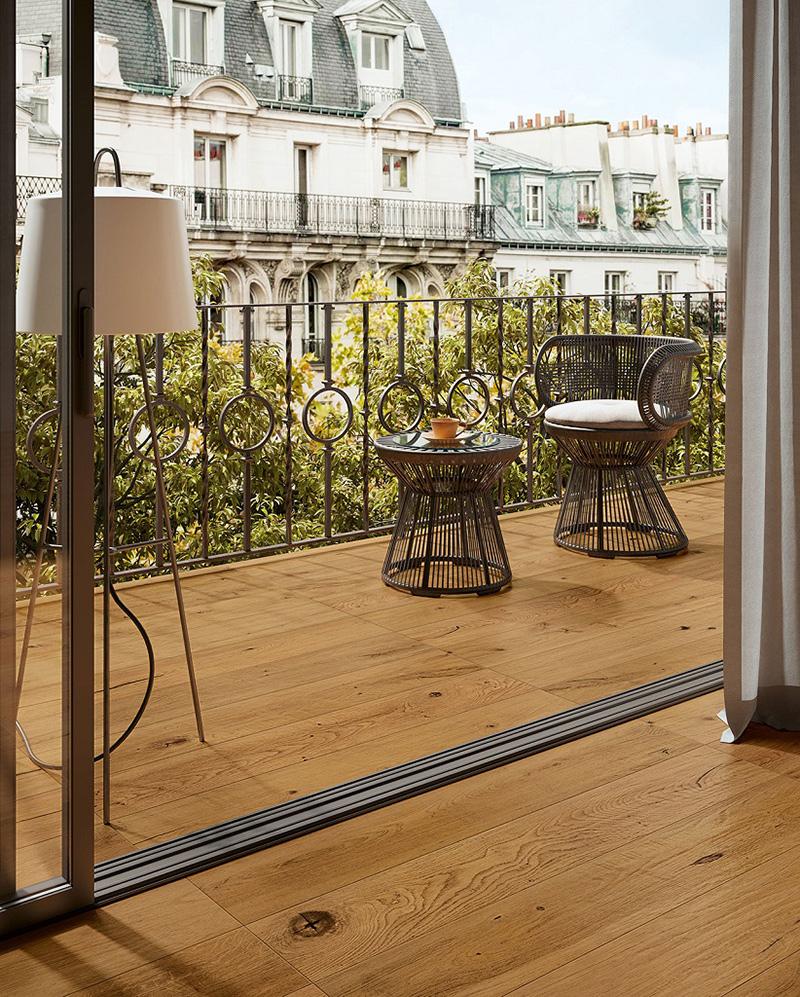 Même petit, ce balcon s'impose comme un grand avec un élégant et chaleureux carrelage imitation parquet bois coordonné avec le carrelage du salon.