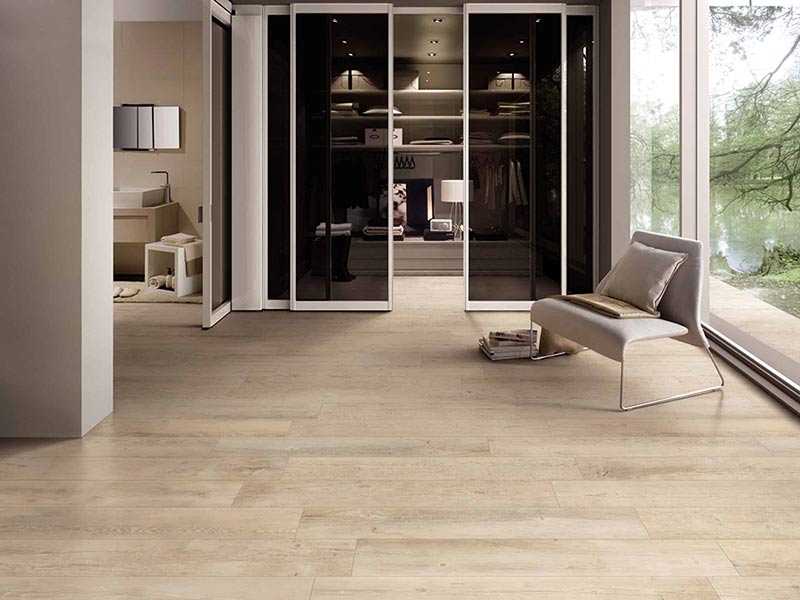 Dans cette grande suite parentale, le carrelage imitation parquet en bois blond au sol apporte une unité lumineuse.