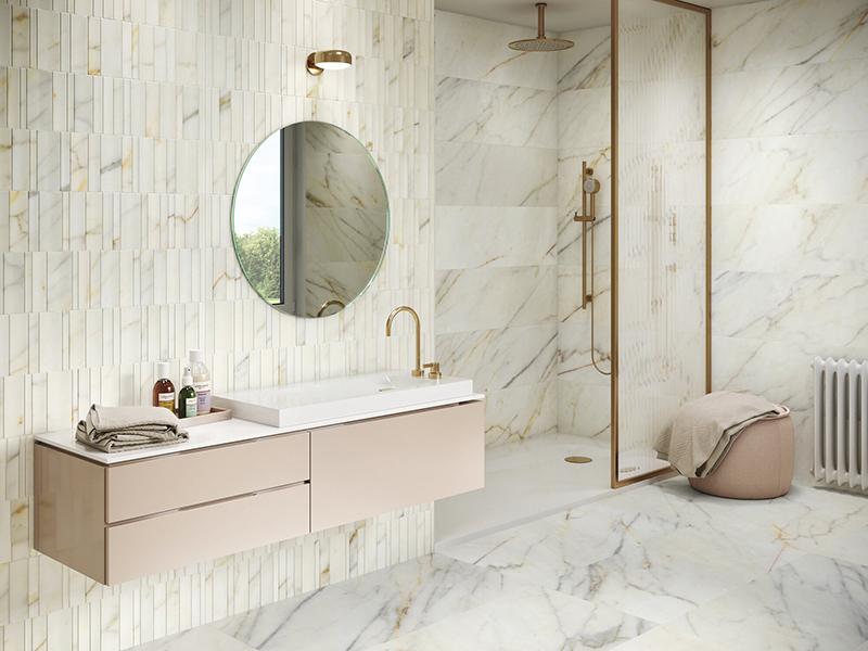 Classique en carreaux grand format sur le sol et dans la douche, le carrelage imitation marbre signe une vraie modernité derrière le lavabo avec un format baguette de différentes largeurs.