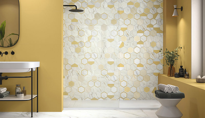 Carreaux hexagonaux imitation et jaune lumineux composent le bon duo de cette salle de bain vitaminée.