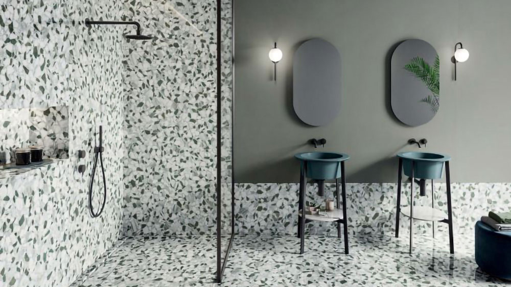 Dans cette salle de bain, mur et sol s'égayent d'un carrelage façon terrazzo en vert et imitation marbre.