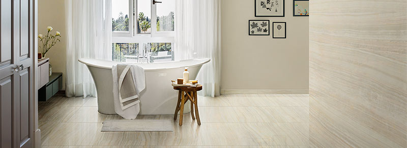 Salle de bain avec baignoire et au sol un carrelage imitation marbre