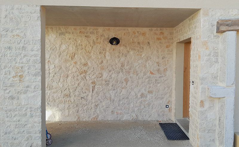 Murs extérieurs en parement pierre naturelle réalisés par Le Carrelage Bugiste extérieur à Belley pour un client à Corbonod